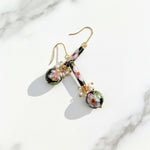 Hand-painted cloisonné floral drop earrings with pearls on a marble surface
