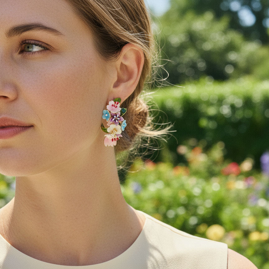 Woman wearing colorful floral earrings with a blurred garden background