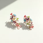 Colorful floral earrings on a light background