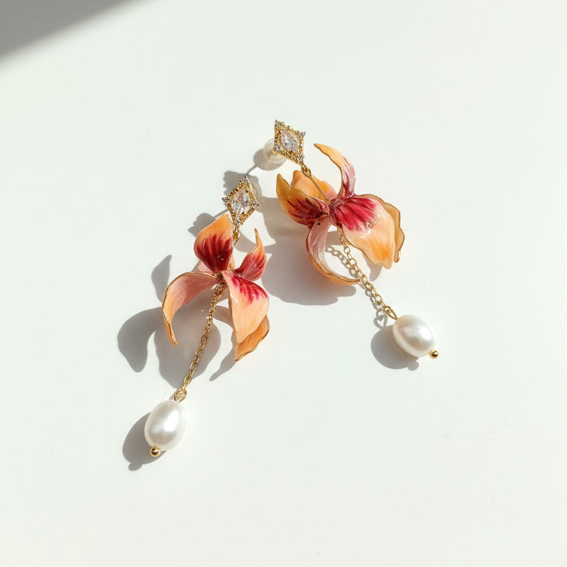 Floral enamel and pearl drop earrings with CZ accents in sunlight.