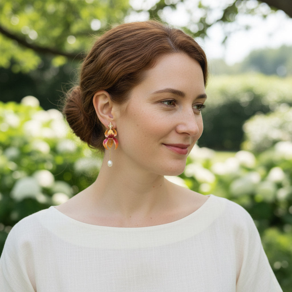Model wearing hand-painted orchid earrings with pearl drops.