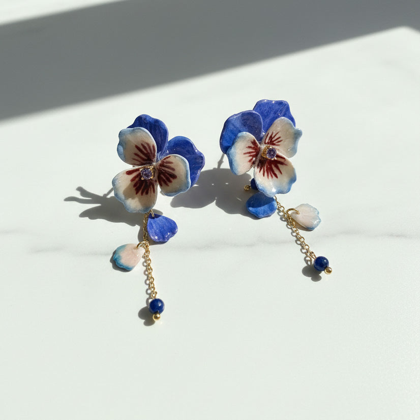 Floral earrings with blue and white flowers on a light background