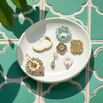 Convertible cloisonné earring components on white ceramic plate.