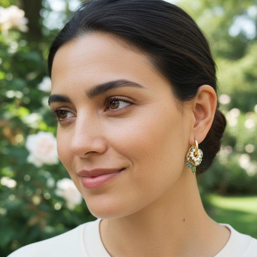 Model wearing multicolor cloisonné hoop earrings outdoors.