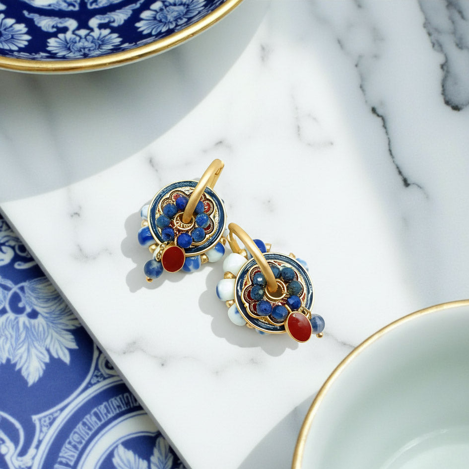 Cloisonné enamel earrings with lapis and red porcelain accents on marble plate.