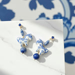 Blue porcelain horse earrings with semi-precious stones on marble background
