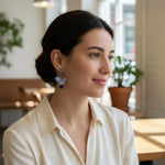 Woman wearing porcelain horse earrings in a cafe setting