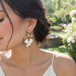 Woman wearing handcrafted porcelain floral hoop earrings in natural sunlight
