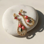 Pink Bellflower Enamel Drop Earrings on a white stone surface