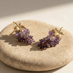 Handcrafted amethyst grape cluster earrings with 18K gold-plated brass on natural limestone.