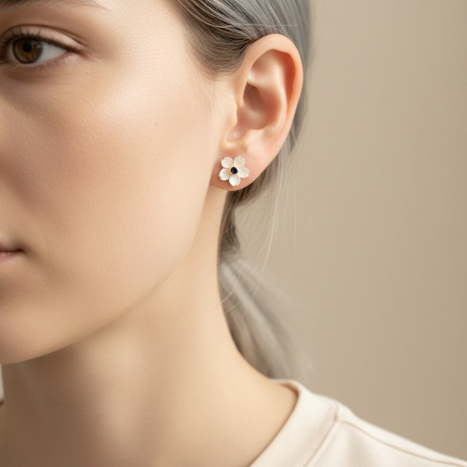 Close-up of a woman wearing a floral earring with a neutral background