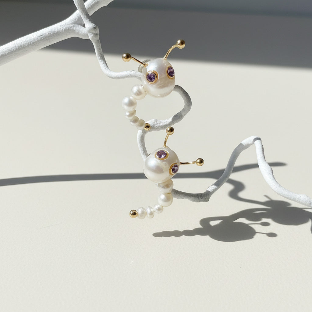 Pearl insect-shaped jewelry on a white branch