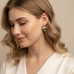 Woman wearing a pair of earrings with a neutral background