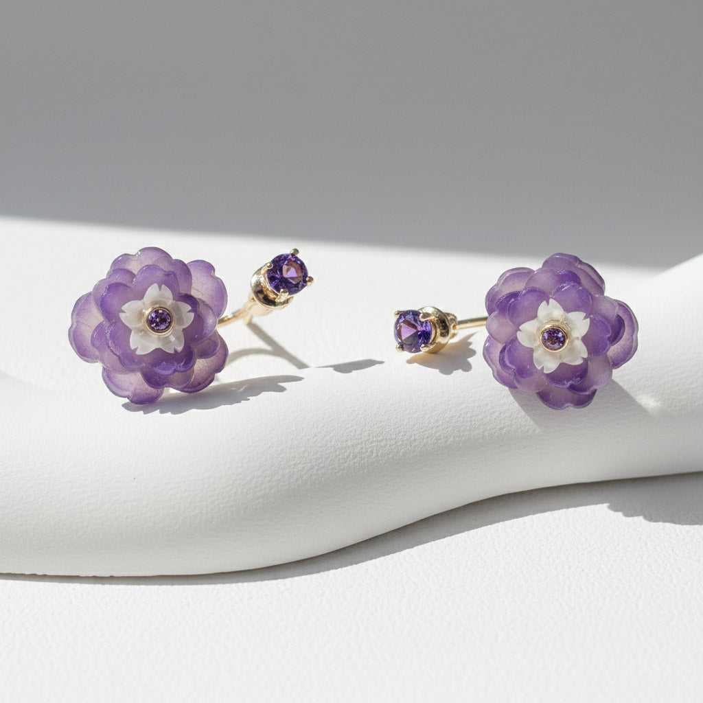 Pair of purple flower earrings on a white surface