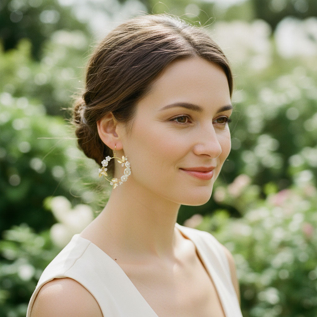 Woman with styled hair and earrings in a garden setting