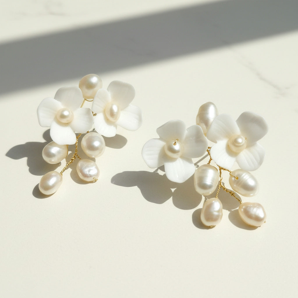 Pearl and white flower earrings on a light background