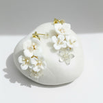 Floral earrings on a white stone surface