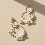 Close-up of A2K London floral pearl hoop earrings with CZ glass accents and resin blossoms.