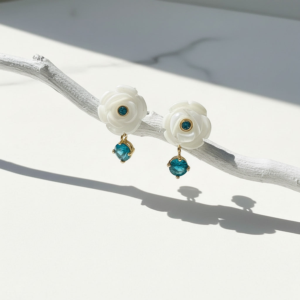 Pair of floral earrings with turquoise stones on a white surface