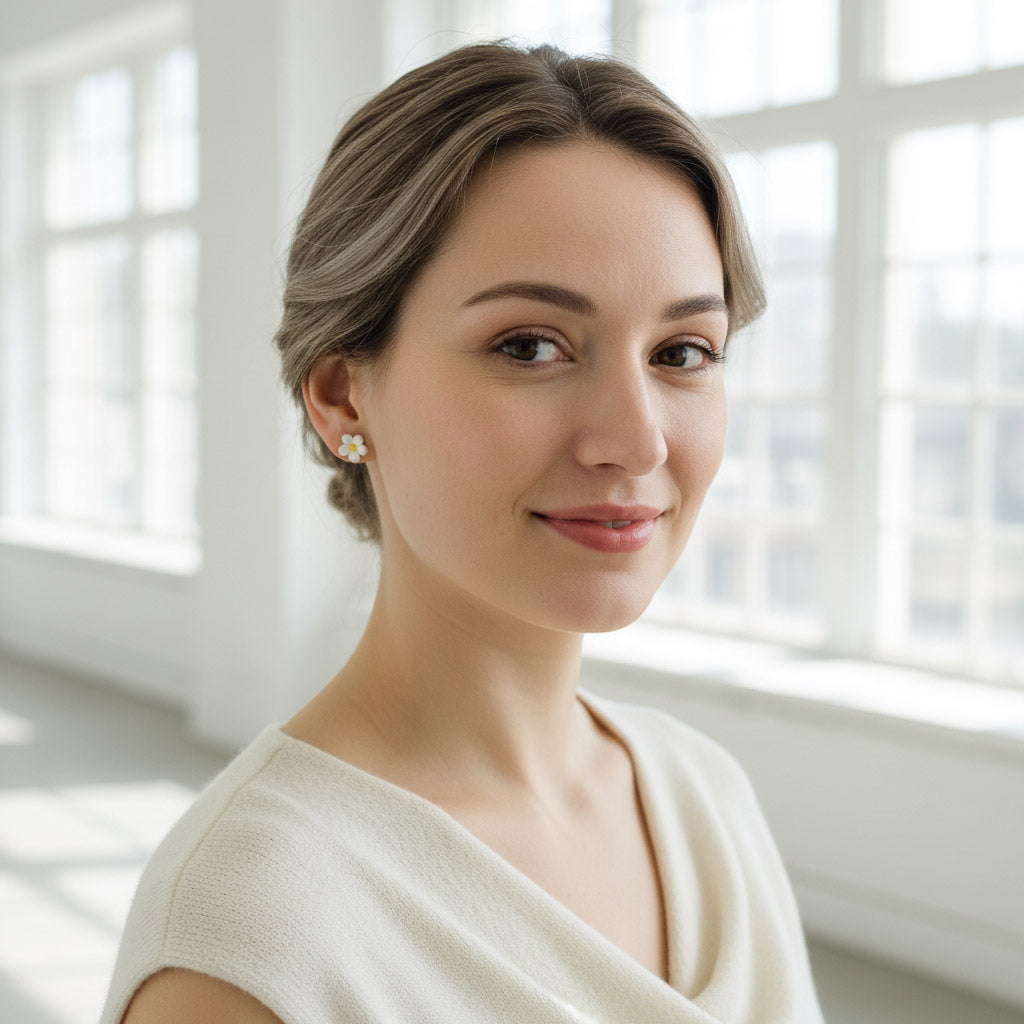 Woman wearing earrings in a bright room with large windows