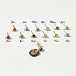 Custom birthstone earrings with interchangeable studs for each month shown beside gold and navy beaded dangle earring.