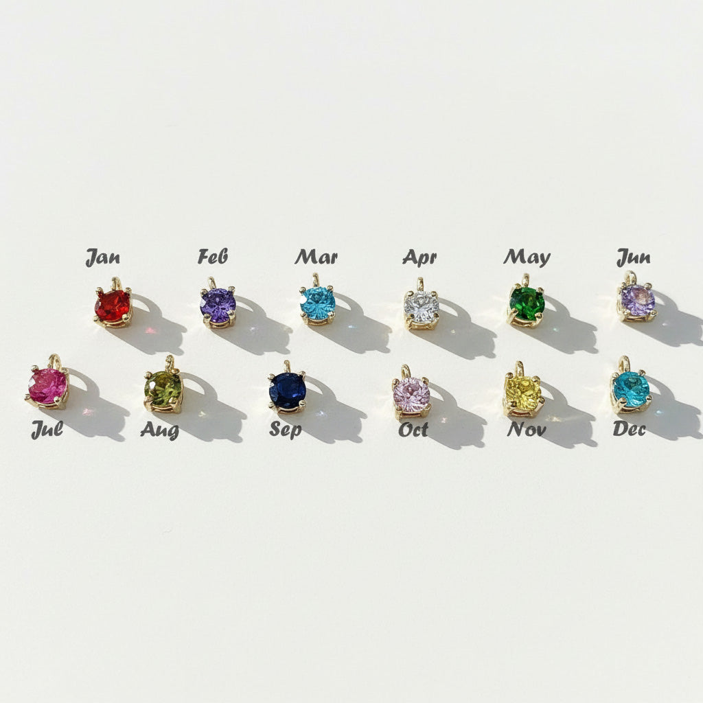 Row of gemstone pendants corresponding to each month on a light background