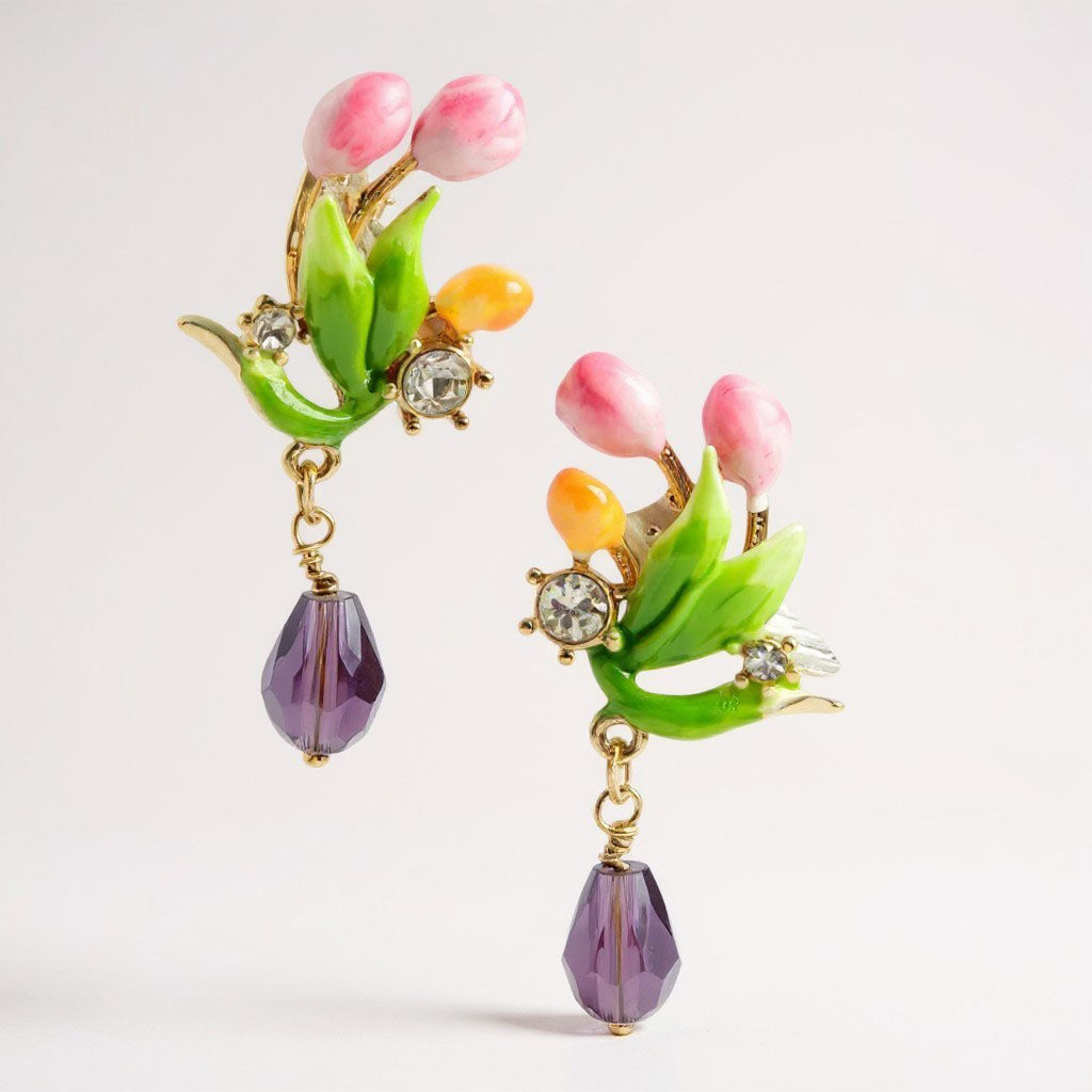 Colorful floral earrings with green leaves and purple beads on a light gray background