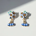 Floral earrings with blue and white flowers on a light background