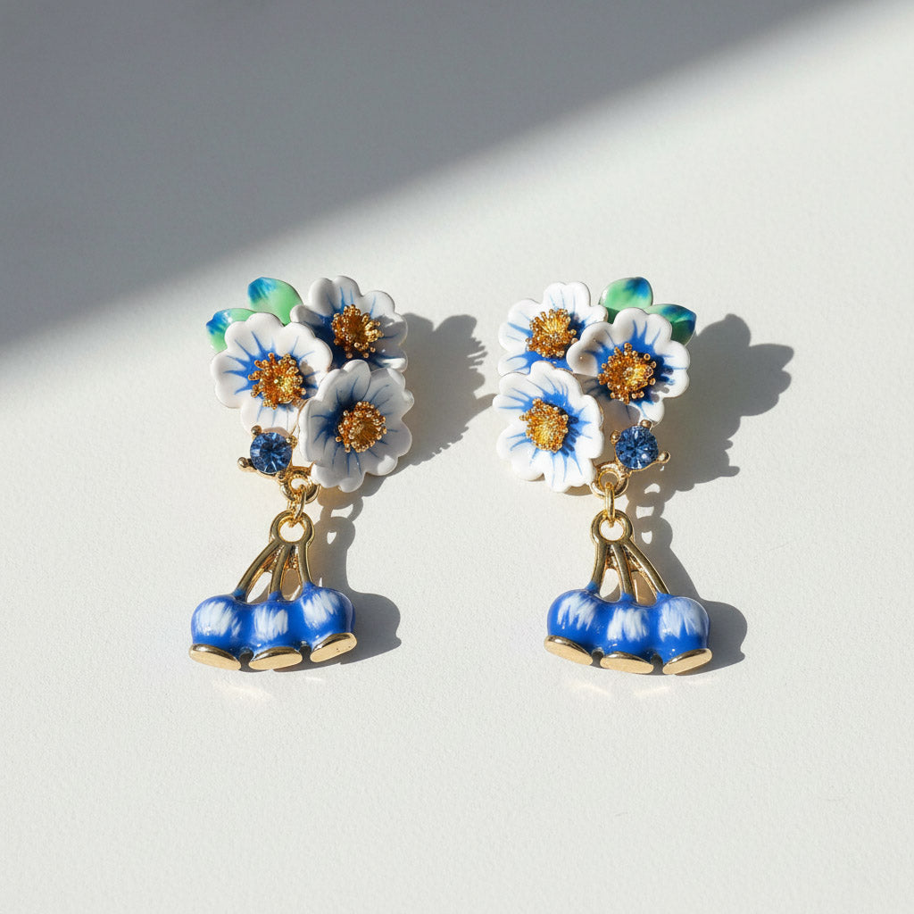Floral earrings with blue and white flowers on a light background