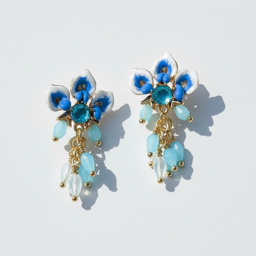 Floral earrings with blue and gold details on a light background