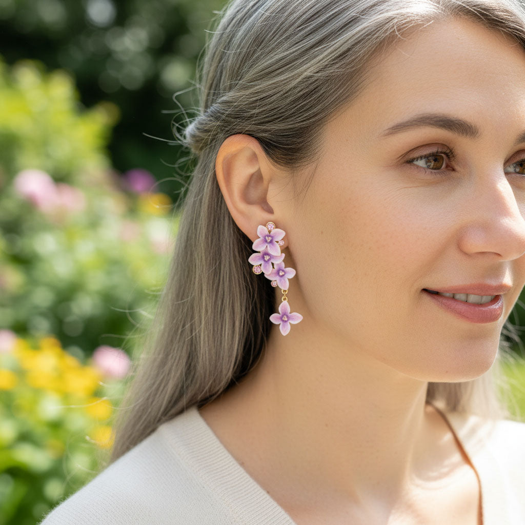 Woman wearing floral earrings with a garden background