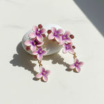 Floral earrings with pink and purple flowers on a light background