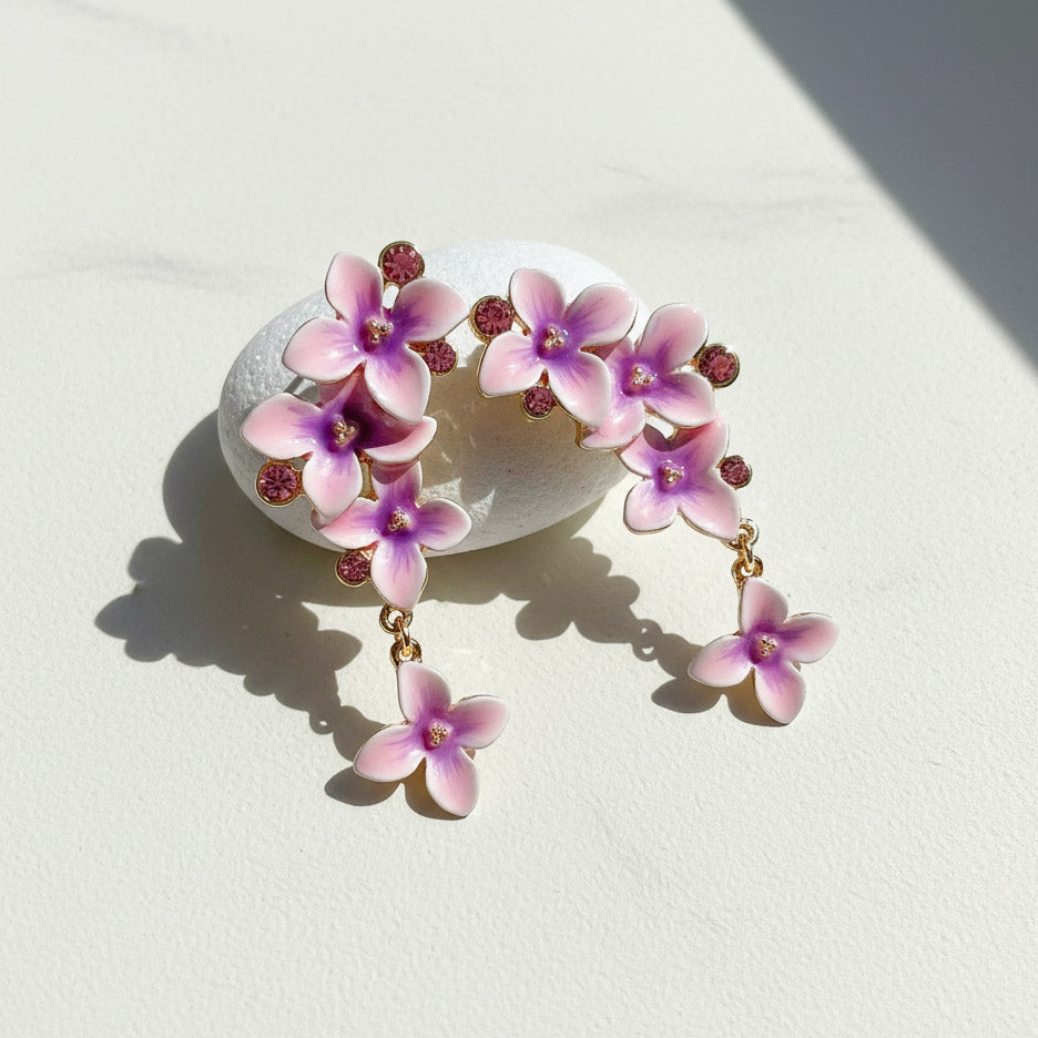 Floral earrings with pink and purple flowers on a light background