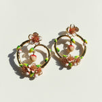 Pair of floral hoop earrings on a light background