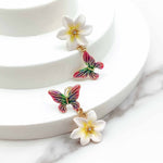 Colorful butterfly and flower earrings on a white background
