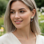 Woman wearing floral earrings with a blurred natural background