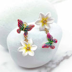 Colorful butterfly earrings with white flowers on a white background