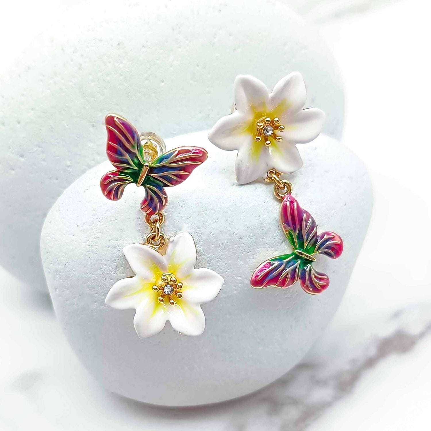 Colorful butterfly earrings with white flowers on a white background