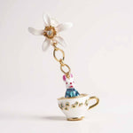 Earring with a rabbit in a teacup and a flower on a white background