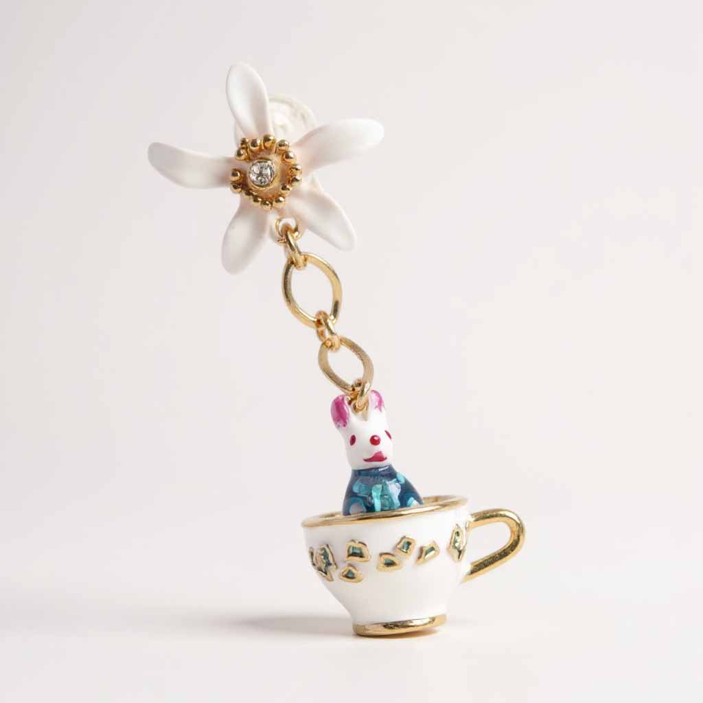 Earring with a rabbit in a teacup and a flower on a white background
