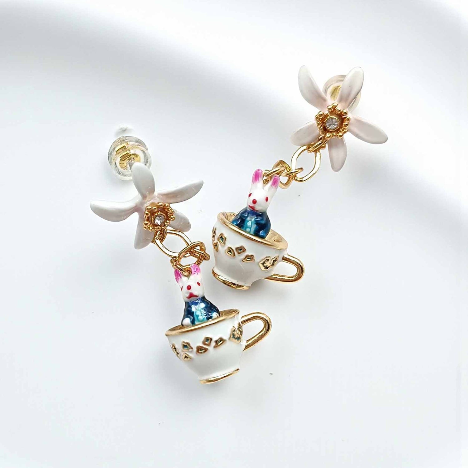 Earrings with teacup and rabbit design on a white background
