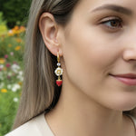 Close-up of a woman wearing colorful earrings with a blurred floral background