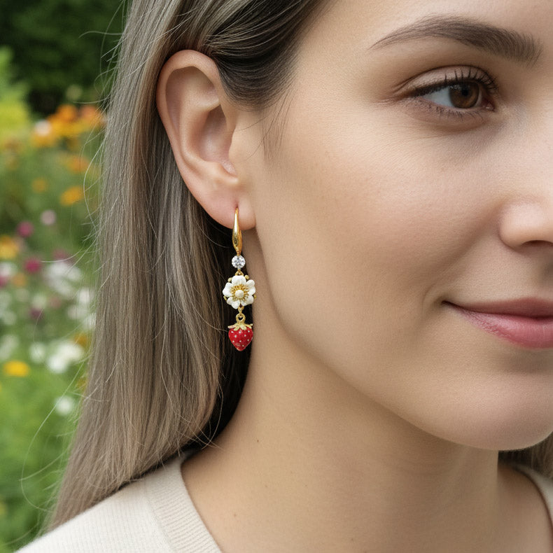 Close-up of a woman wearing colorful earrings with a blurred floral background