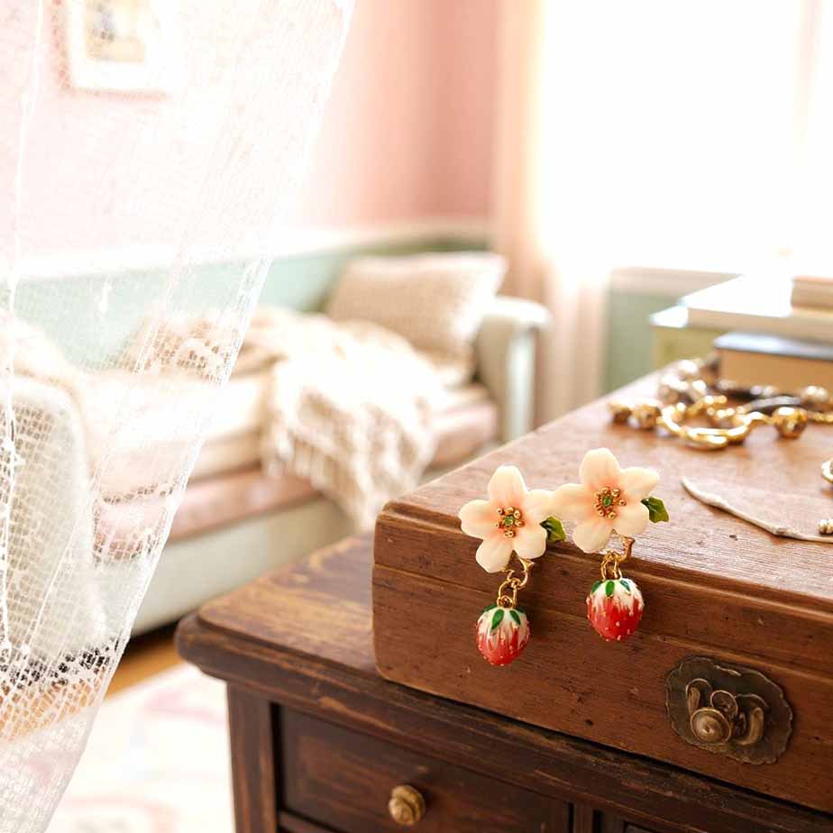 Floral earrings on a wooden jewelry box with a soft, blurred background