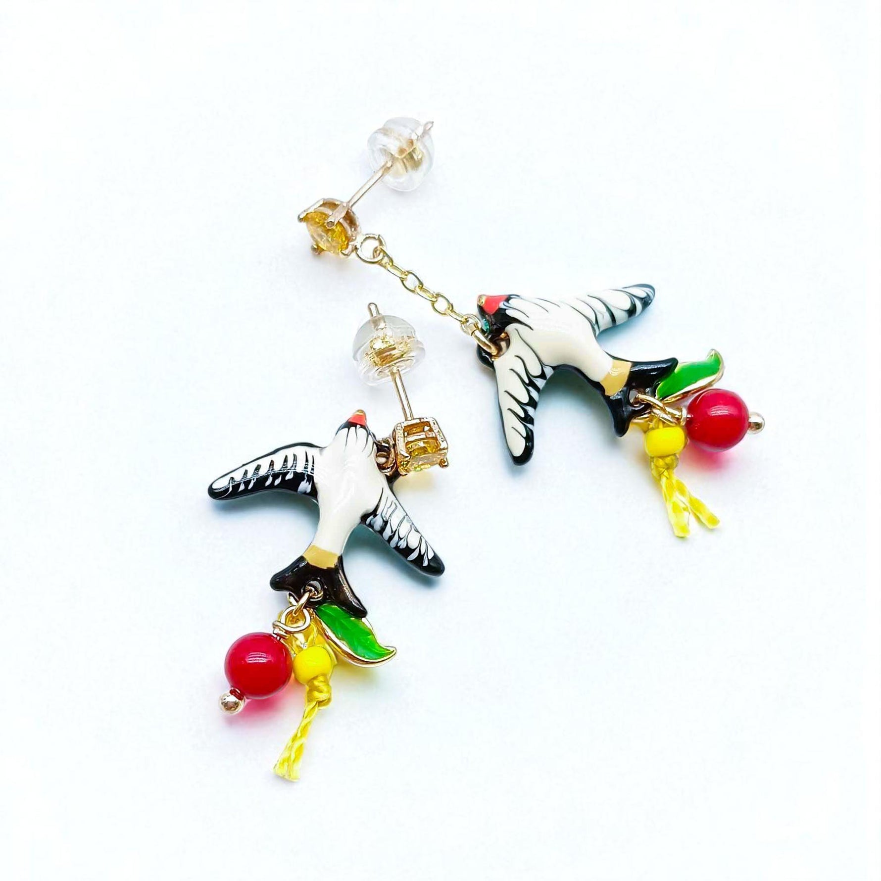 Colorful bird-shaped earrings on a white background