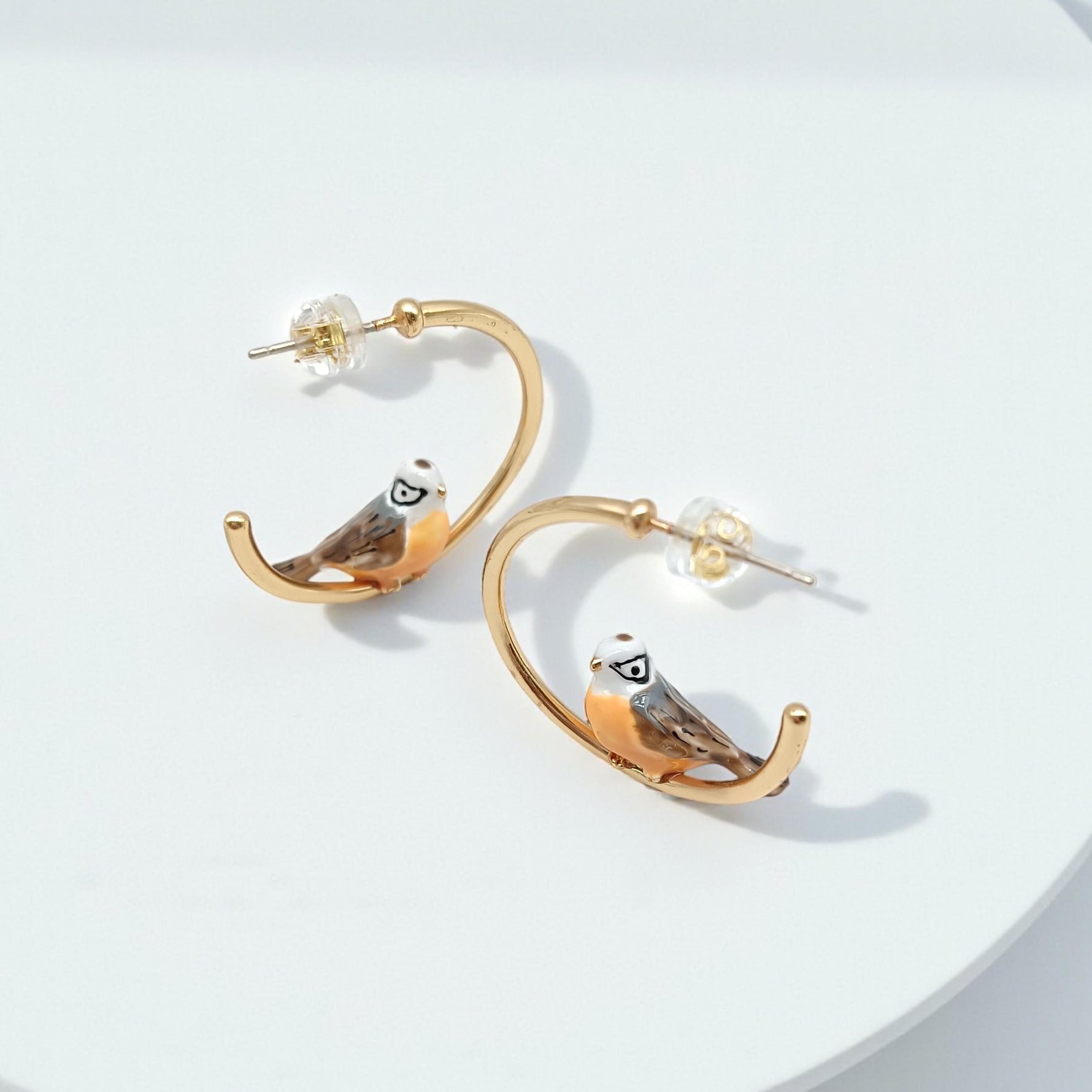 Gold hoop earrings with owl design on a white background