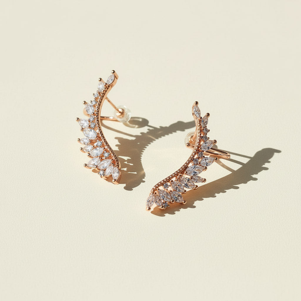 Rose gold earrings with clear gemstones on a beige background