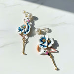 Flamingo-shaped earrings with floral details on a white background