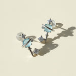 Pair of earrings with blue gemstones on a beige background