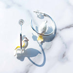 Bird-shaped earrings on a light background